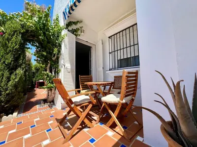 two chairs and a table on a patio at Apartamento Alextia La Barrosa in Chiclana de la Frontera