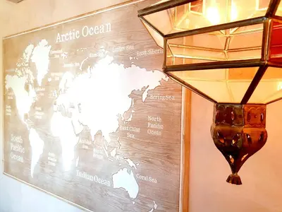 a lamp hanging on a wall with a world map at Sherryflat Senovilla in Jerez de la Frontera