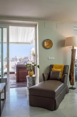 a living room with a brown couch and a window at ***** ATTIC WITH IMPRESSIVE VIEWS AND JACUZZI in Cádiz