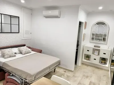 a white bedroom with a bed and a window at San Francisco 15 in Cádiz