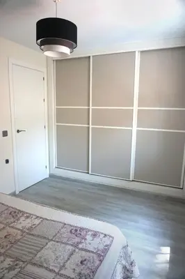 a bedroom with white closet doors and a rug at Relax y playa en la Barrosa in Chiclana de la Frontera