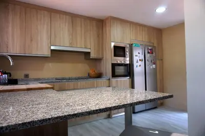 a kitchen with a granite counter top and a refrigerator at Relax y playa en la Barrosa in Chiclana de la Frontera