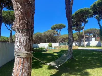 a hammock tied to a tree in a yard at Relax y playa en la Barrosa in Chiclana de la Frontera