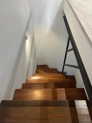 a staircase with wooden floors and a metal rail at El Chicuco en el corazón de Cádiz Grupo AC Gestion in Cádiz