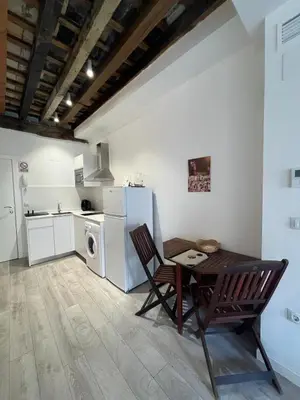 a kitchen with a table and chairs and a refrigerator at El Chicuco en el corazón de Cádiz Grupo AC Gestion in Cádiz