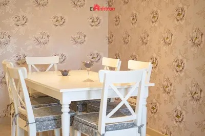 a dining room table and chairs with a flower wallpaper at ATICO NUEVO en el BARRIO ALTO SANLÚCAR in Sanlúcar de Barrameda
