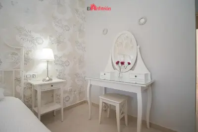 a bedroom with a dressing table and a mirror at ATICO NUEVO en el BARRIO ALTO SANLÚCAR in Sanlúcar de Barrameda