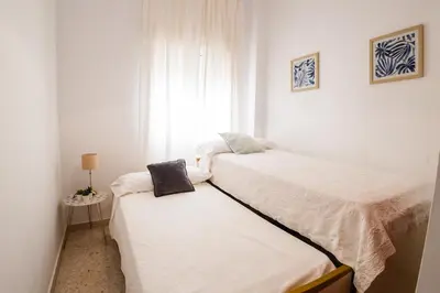 two beds in a small room with a window at Almijar 9 in Sanlúcar de Barrameda