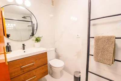 a bathroom with a sink and a toilet and a mirror at Almijar 9 in Sanlúcar de Barrameda
