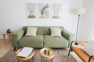a living room with a green couch and a table at Almijar 9 in Sanlúcar de Barrameda
