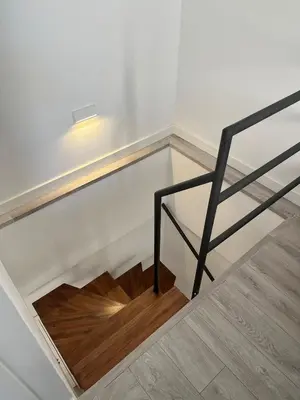 a staircase with a metal railing and a wooden floor at Penthouse La plaza en Cádiz Centro Grupo AC Gestion in Cádiz