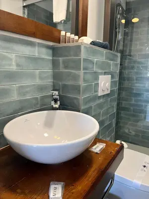 a bathroom with a white bowl sink on a wooden counter at Penthouse La plaza en Cádiz Centro Grupo AC Gestion in Cádiz