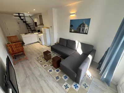 a living room with a couch and a kitchen at Penthouse La plaza en Cádiz Centro Grupo AC Gestion in Cádiz