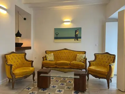 a living room with two yellow couches and a coffee table at El Bastinazo con Terraza Privada Grupo AC Gestion in Cádiz