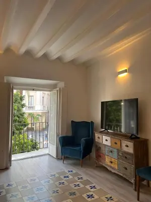 a living room with a tv and a blue chair at El Bastinazo con Terraza Privada Grupo AC Gestion in Cádiz