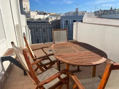 a wooden table and chairs on a balcony at El Bastinazo con Terraza Privada Grupo AC Gestion in Cádiz