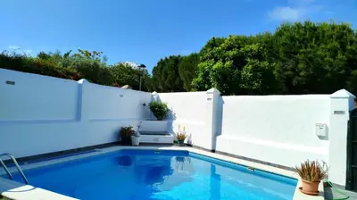 a swimming pool in front of a white fence at Casa Velero 32 in Sanlúcar de Barrameda