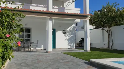 a white house with a patio with a table at Casa Velero 32 in Sanlúcar de Barrameda