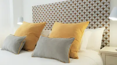 a bed with four pillows and a headboard at Casa Velero 32 in Sanlúcar de Barrameda