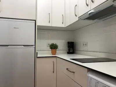 a kitchen with white cabinets and a refrigerator at APARTAMENTOs IGLESIA DE SANTIAGO in Jerez de la Frontera