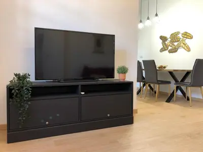 a large black entertainment center with a flat screen tv at APARTAMENTOs IGLESIA DE SANTIAGO in Jerez de la Frontera