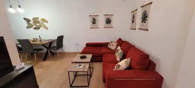 a living room with a red couch and a table at APARTAMENTOs IGLESIA DE SANTIAGO in Jerez de la Frontera