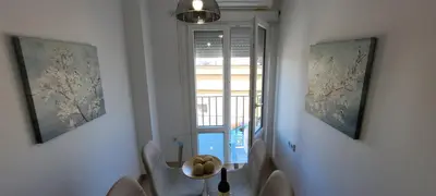 a room with a table and two paintings on the wall at APARTAMENTOs IGLESIA DE SANTIAGO in Jerez de la Frontera