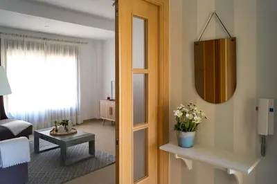 a living room with a bed and a mirror at Casa de la Jara 10 in Sanlúcar de Barrameda