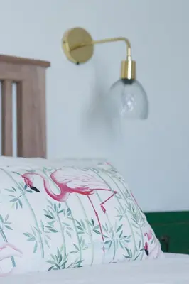 a bed with a pink flamingo pillow and a lamp at Casa de la Jara 10 in Sanlúcar de Barrameda