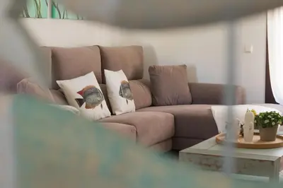 a living room with a couch with pillows and a table at Casa de la Jara 10 in Sanlúcar de Barrameda