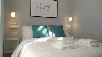 a bedroom with a white bed with towels on it at Sherryflat Los Cisnes in Jerez de la Frontera