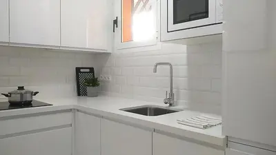 a kitchen with white cabinets and a sink at Sherryflat Los Cisnes in Jerez de la Frontera