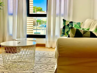 a living room with a couch and a table and a window at Allo Apartments Valdespino Parking Centro 2 Habitaciones in Jerez de la Frontera