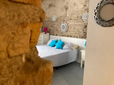a bedroom with a bed with blue pillows at La Herrería de Sagasta in Cádiz