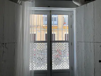 an open door with a window with a view of a building at La Herrería de Sagasta in Cádiz