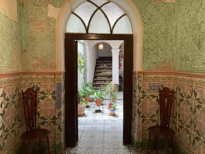 an open hallway with two chairs and an arch way at La Herrería de Sagasta in Cádiz