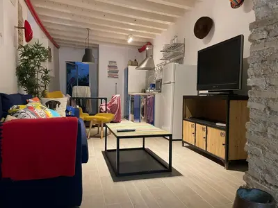 a living room with a couch and a tv at La Herrería de Sagasta in Cádiz
