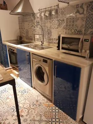 a kitchen with a microwave and a washing machine at La Herrería de Sagasta in Cádiz