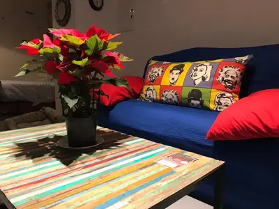 a blue couch with a table and a vase with flowers at La Herrería de Sagasta in Cádiz