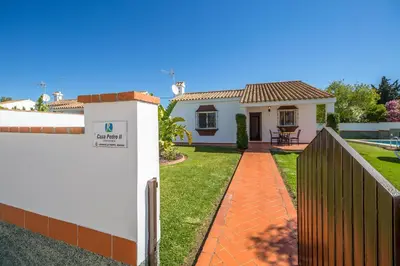a house with a fence and a yard at Chalet Pedro II in Conil de la Frontera