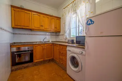 a kitchen with a white refrigerator and a dishwasher at Chalet Pedro II in Conil de la Frontera