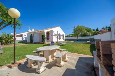 a picnic table in the yard of a house at Chalet Pedro II in Conil de la Frontera