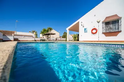 a swimming pool in front of a building at Chalet Pedro II in Conil de la Frontera