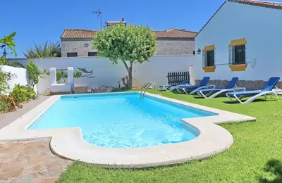 a swimming pool in the yard of a house at Chalet la Dehesa in Conil de la Frontera