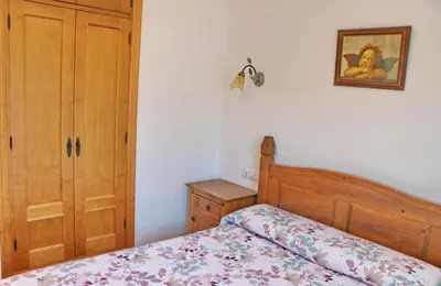 a bedroom with a bed and a dresser and a picture at Chalet Dehesa Villa in Conil de la Frontera