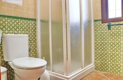 a bathroom with a toilet and a shower at Chalet Dehesa Villa in Conil de la Frontera
