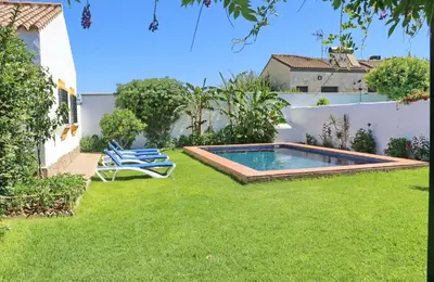 a backyard with a swimming pool and lawn at Chalet Dehesa Villa in Conil de la Frontera