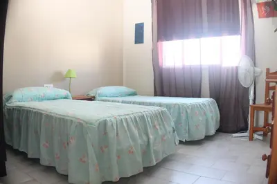 a room with two beds and a window at Apartamento La Barca in Chiclana de la Frontera