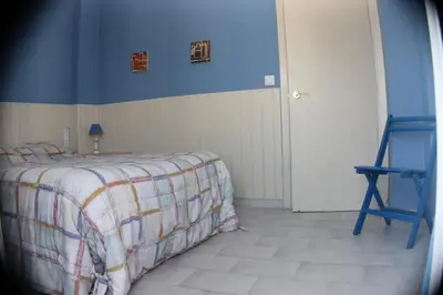 a bedroom with a bed and a blue wall at Apartamento La Barca in Chiclana de la Frontera