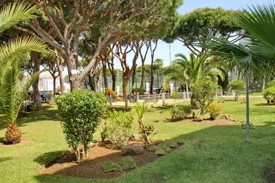 a park with trees and plants and a playground at Apartamento La Barca in Chiclana de la Frontera